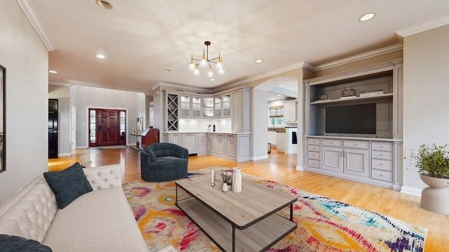 living room featuring recessed lighting, baseboards, light wood-style flooring, and ornamental molding