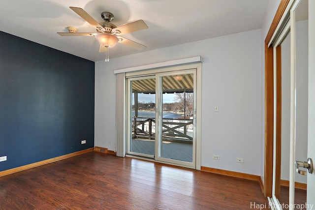 spare room featuring ceiling fan, baseboards, and dark wood-style flooring