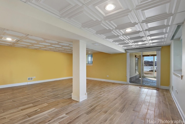 spare room featuring visible vents, light wood-style flooring, an ornate ceiling, and baseboards