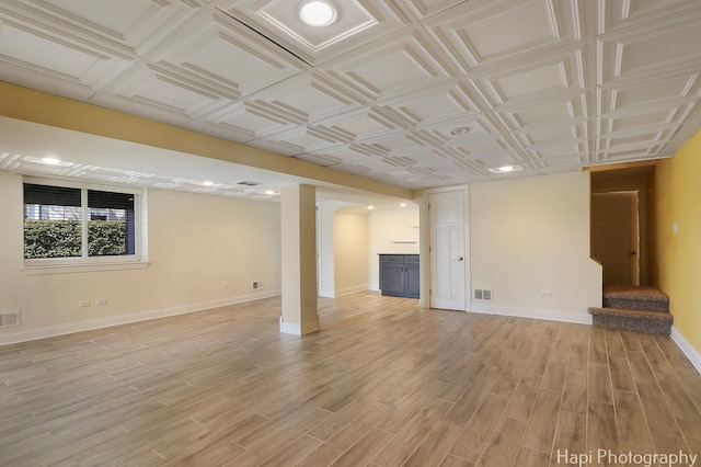 unfurnished living room featuring visible vents, baseboards, an ornate ceiling, stairs, and light wood-style floors