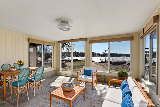 sunroom with plenty of natural light and a water view