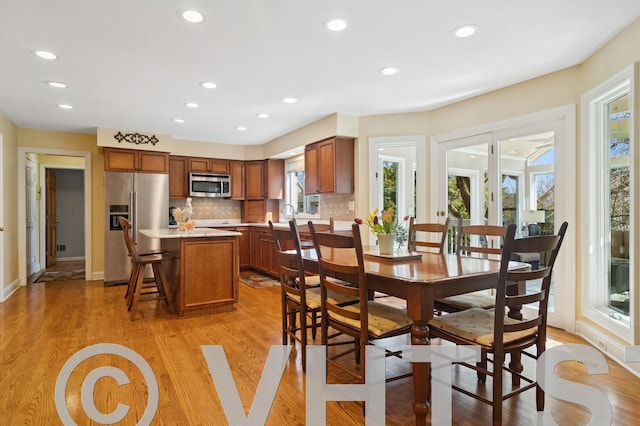 dining space with light wood-style flooring, recessed lighting, and baseboards