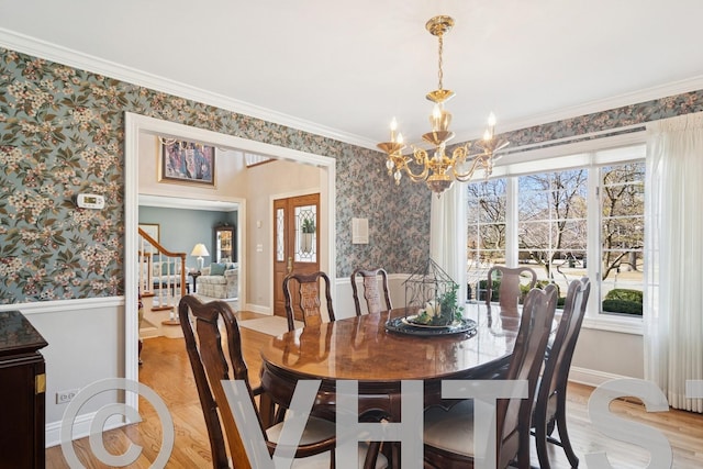 dining room with an inviting chandelier, wallpapered walls, and light wood-style floors