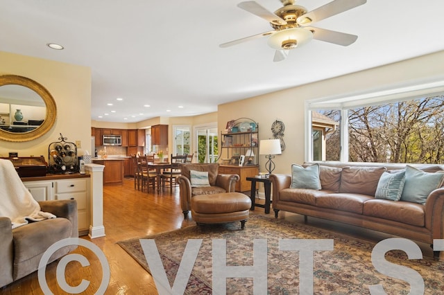 living area featuring recessed lighting, light wood-type flooring, and a ceiling fan