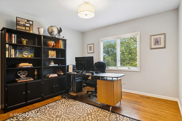 office space with visible vents, baseboards, and wood finished floors