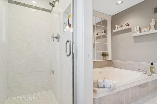 bathroom featuring visible vents, a stall shower, and a bath