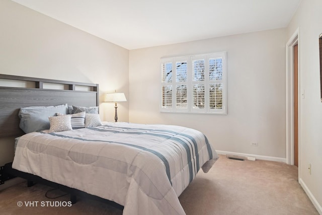 carpeted bedroom with visible vents and baseboards