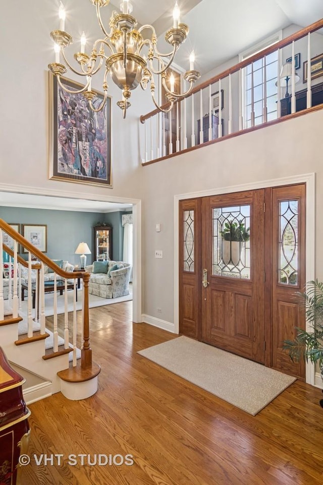 foyer with stairway, wood finished floors, and a healthy amount of sunlight