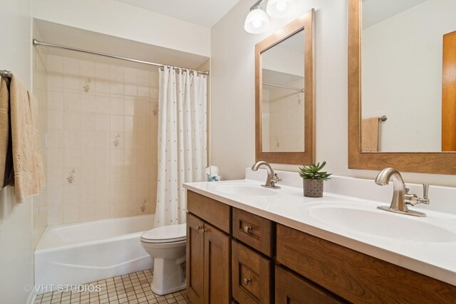 full bath with tile patterned flooring, double vanity, toilet, and a sink