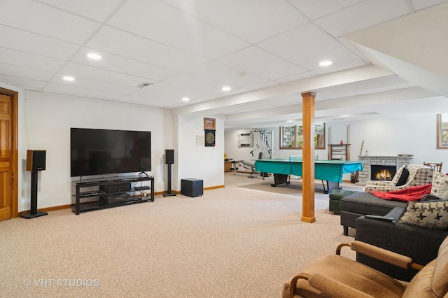 carpeted living room with visible vents, baseboards, recessed lighting, a lit fireplace, and a paneled ceiling