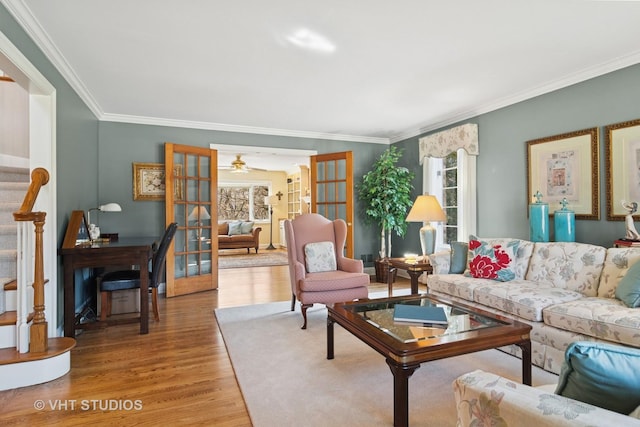 living area with stairway, french doors, light wood finished floors, and a healthy amount of sunlight