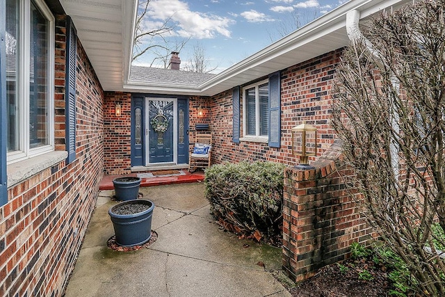 view of exterior entry featuring brick siding