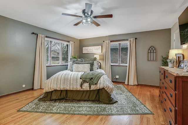 bedroom featuring a ceiling fan, light wood-style flooring, and baseboards