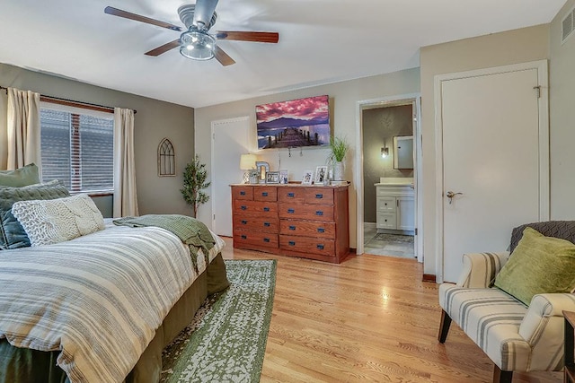 bedroom featuring light wood-style floors, visible vents, connected bathroom, and ceiling fan