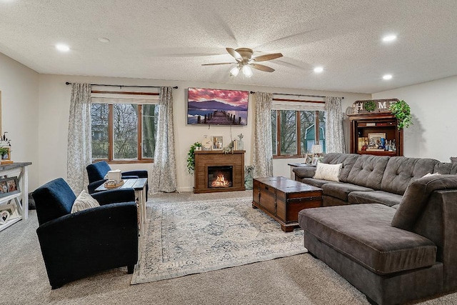 living area with a textured ceiling, a lit fireplace, carpet, and recessed lighting