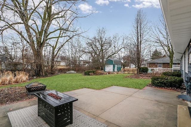 view of patio with a fire pit and an outdoor structure