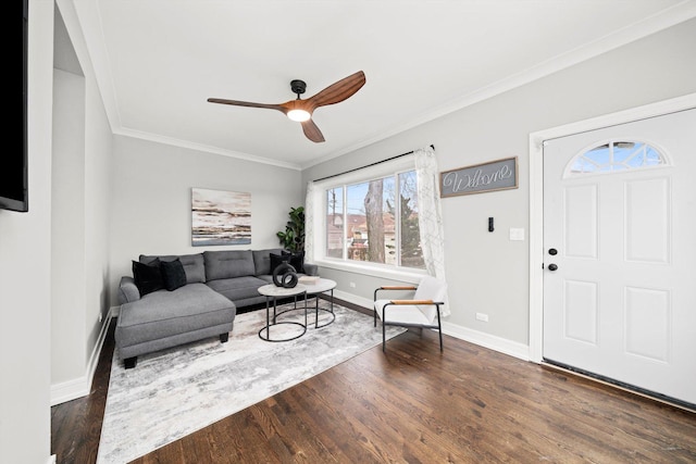 living area featuring crown molding, baseboards, ceiling fan, and wood finished floors