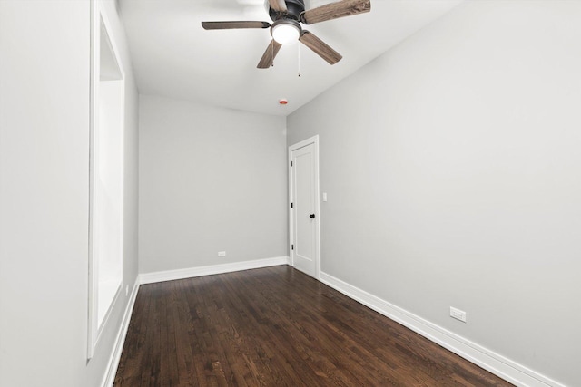 spare room featuring dark wood-style floors, ceiling fan, and baseboards