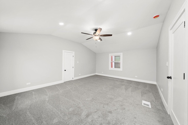 additional living space with ceiling fan, visible vents, baseboards, vaulted ceiling, and carpet