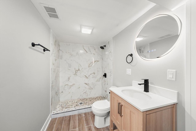 full bath featuring wood tiled floor, a marble finish shower, visible vents, and vanity