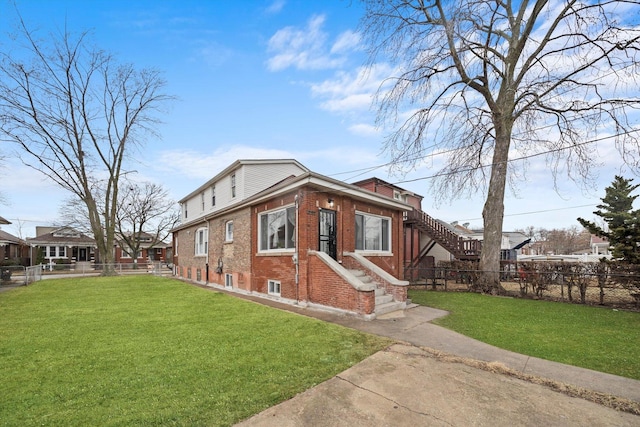 view of home's exterior featuring brick siding, a lawn, and fence