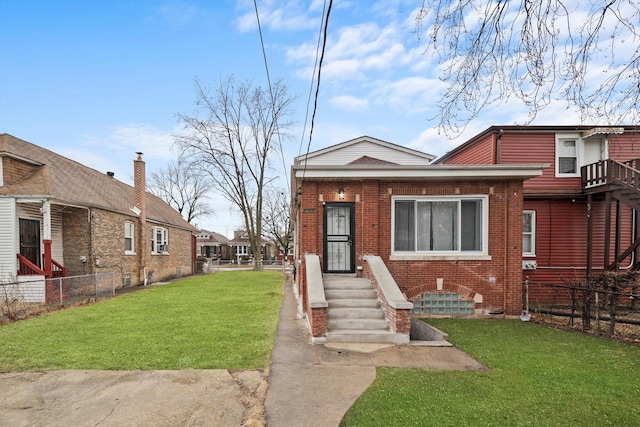 view of front of property featuring brick siding, a front lawn, and fence