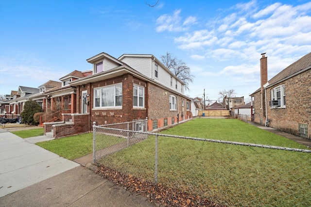 view of front facade featuring brick siding, a front lawn, cooling unit, and fence