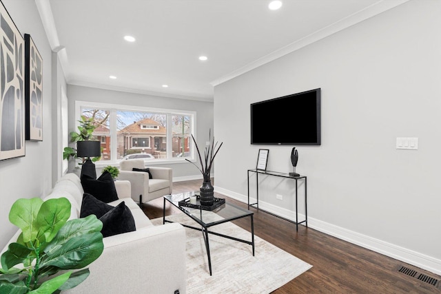 living room featuring visible vents, crown molding, baseboards, and wood finished floors