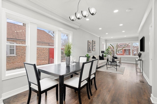 dining space featuring dark wood-style floors, plenty of natural light, visible vents, and crown molding