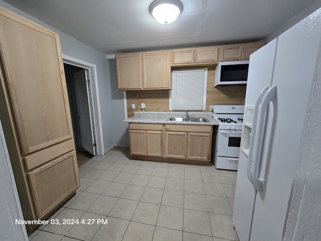 kitchen with light brown cabinetry, white appliances, a sink, and light countertops