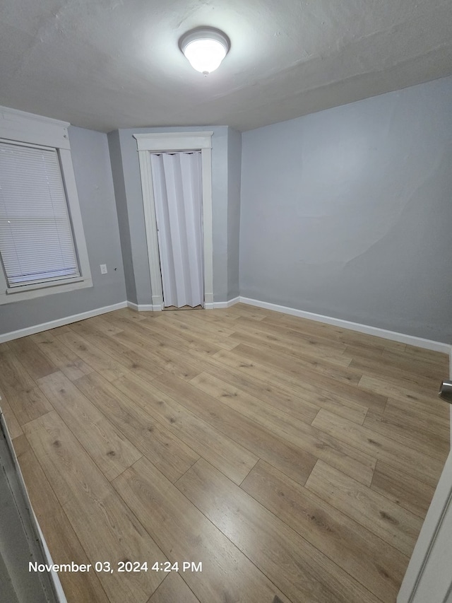 empty room featuring light wood finished floors and baseboards