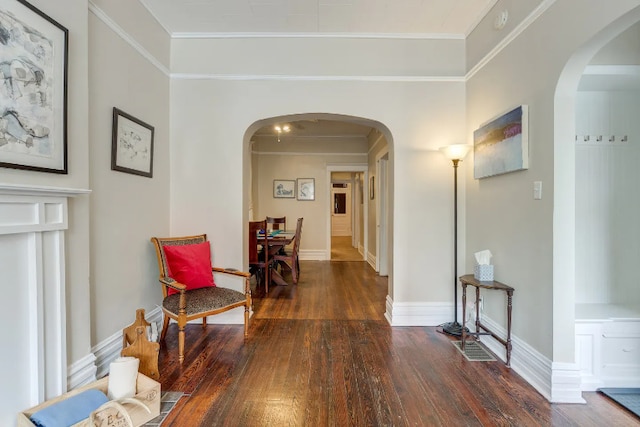 hallway with arched walkways, wood finished floors, and baseboards