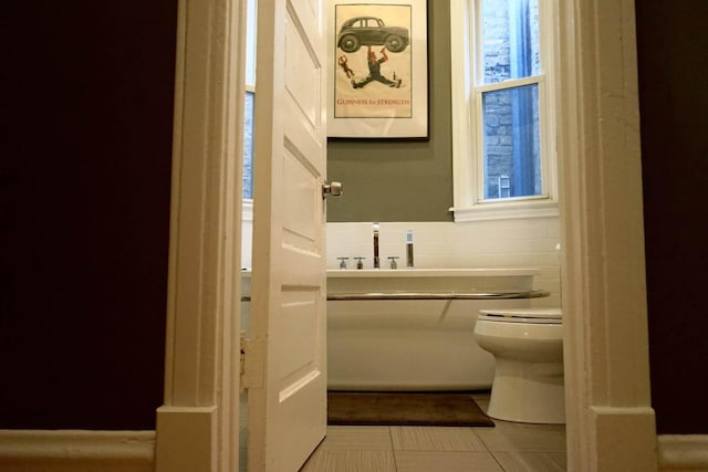 bathroom with toilet and tile patterned floors