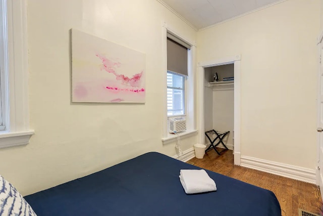 bedroom featuring visible vents, wood finished floors, crown molding, cooling unit, and a closet