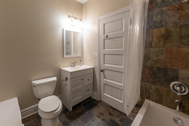 full bathroom featuring toilet, baseboards, stone tile flooring, and vanity