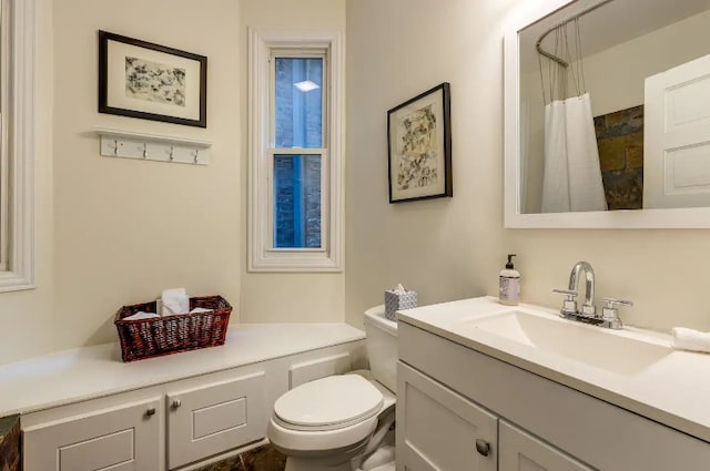 full bath with a shower with shower curtain, vanity, and toilet