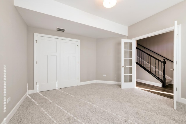 interior space featuring baseboards, visible vents, carpet, french doors, and a closet