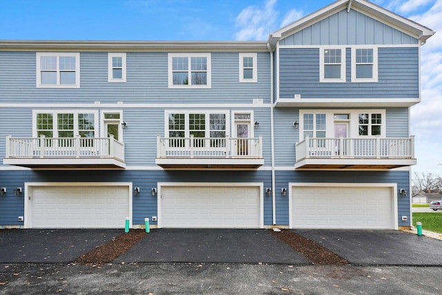 view of front facade with an attached garage, driveway, and board and batten siding