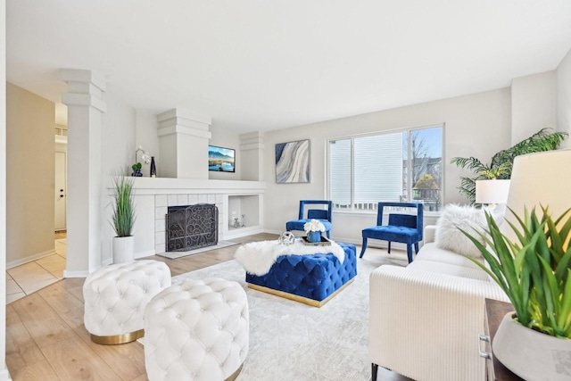 living room with a fireplace, wood finished floors, and baseboards