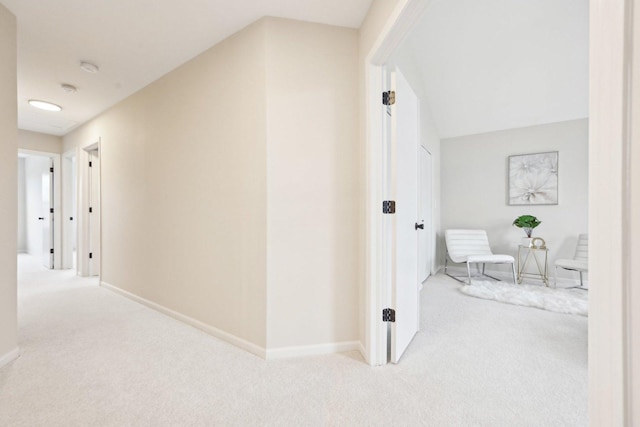 hallway with carpet floors and baseboards