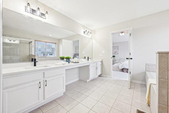 bathroom featuring double vanity, a stall shower, connected bathroom, a sink, and tile patterned flooring