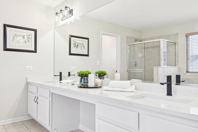 bathroom with a stall shower, tile patterned floors, a sink, and double vanity