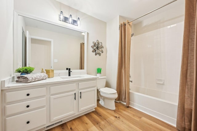 bathroom featuring toilet, shower / bathtub combination with curtain, wood finished floors, and vanity