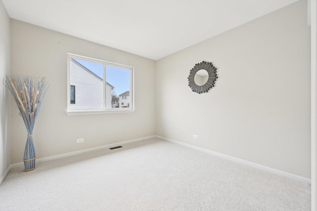 carpeted spare room with visible vents and baseboards