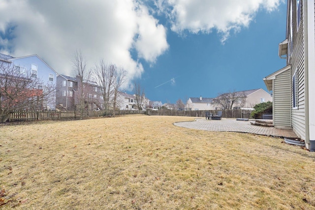 view of yard featuring a patio area, a fenced backyard, and a residential view