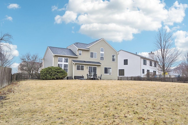 back of house with a lawn and fence