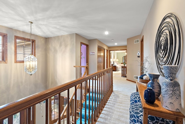 corridor featuring recessed lighting, light carpet, a notable chandelier, visible vents, and an upstairs landing