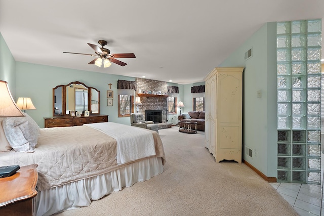 bedroom with light carpet, a fireplace, visible vents, and multiple windows