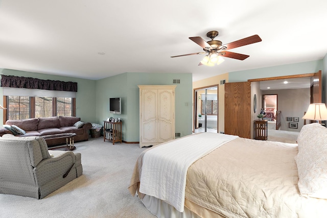 bedroom with light carpet, ceiling fan, visible vents, and baseboards