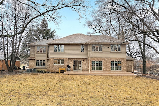 back of property with a patio area, a chimney, a lawn, and brick siding